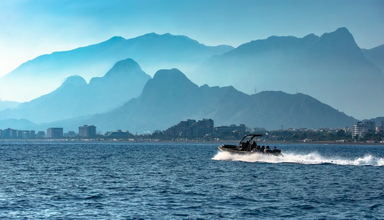 RHIBs on water in front of mountains